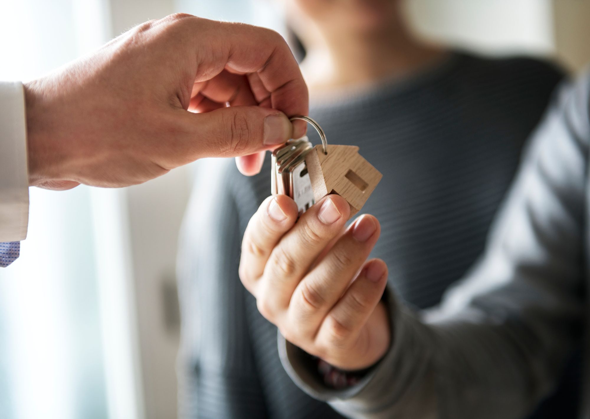real estate agent passing the key to their client