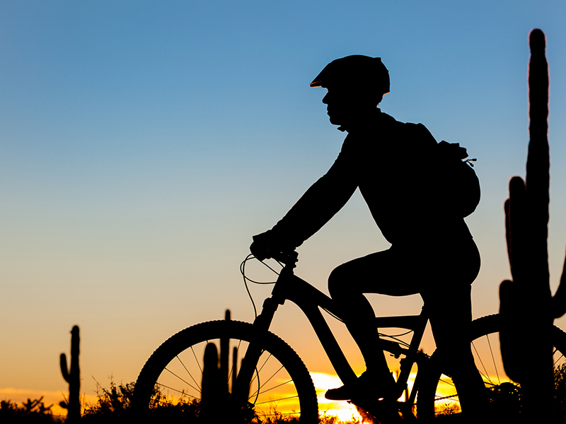 man riding bike on the sunset