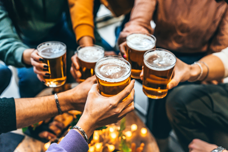 Group of friends drinking and toasting glass of beer